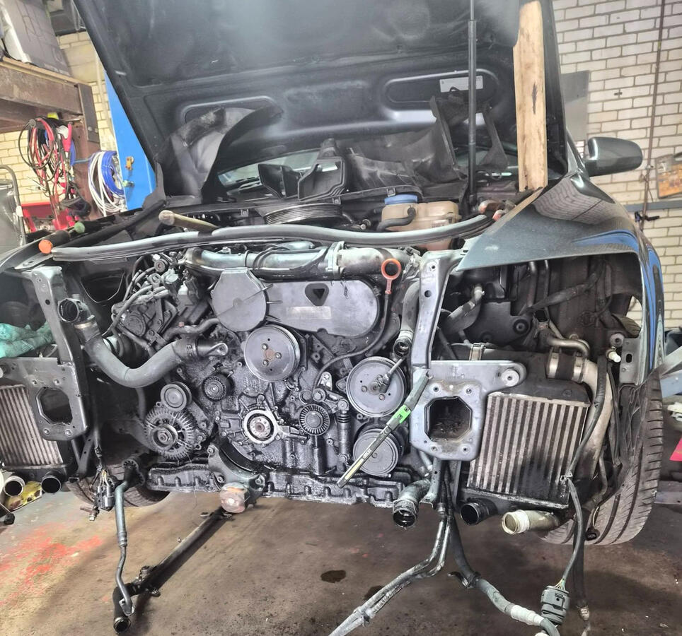 Audi in for Engine Work Audi with bumper, headlights and slam panel removed showing front of engine